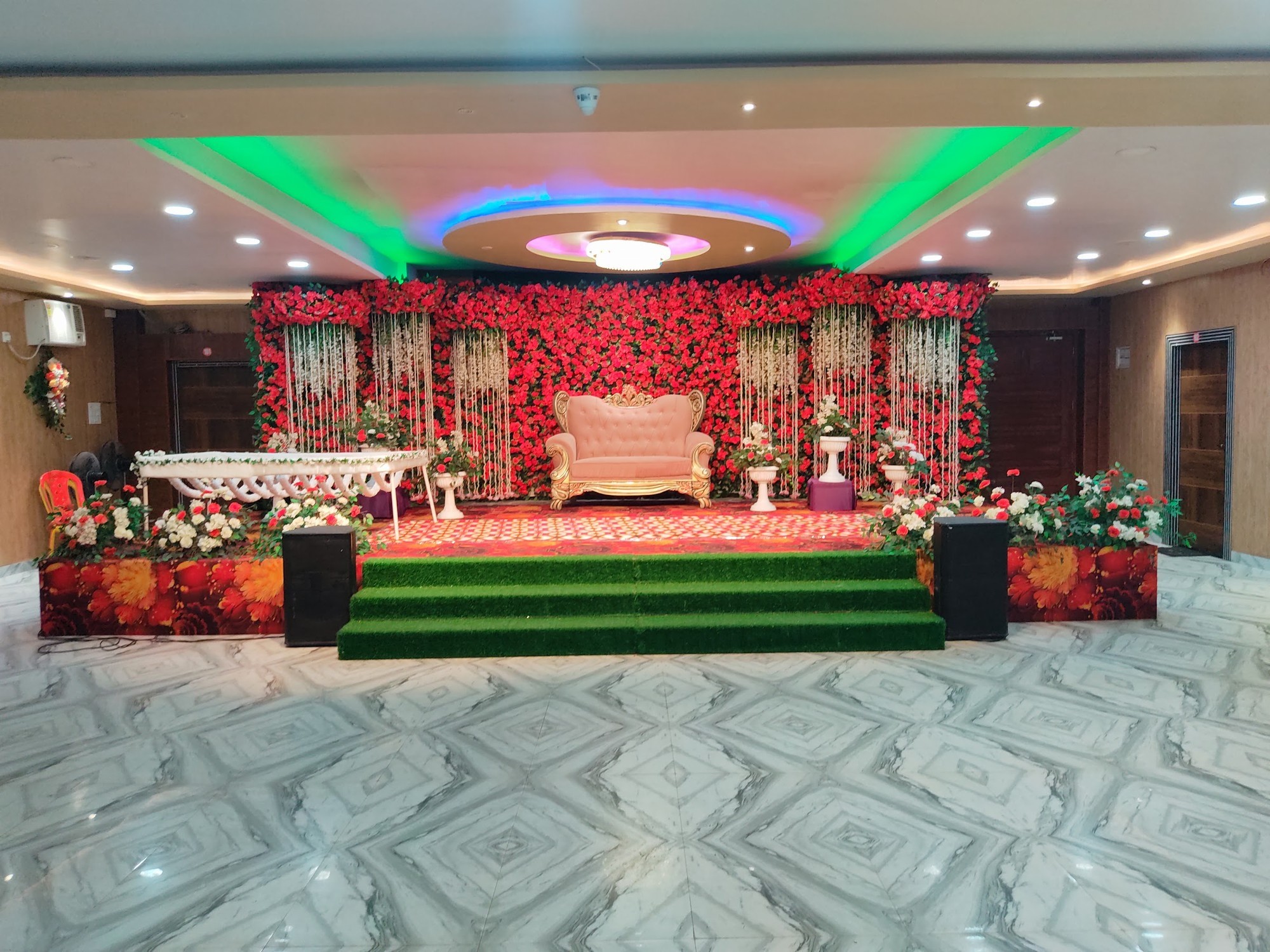 Wedding stage with red rose wall backdrop and royal throne