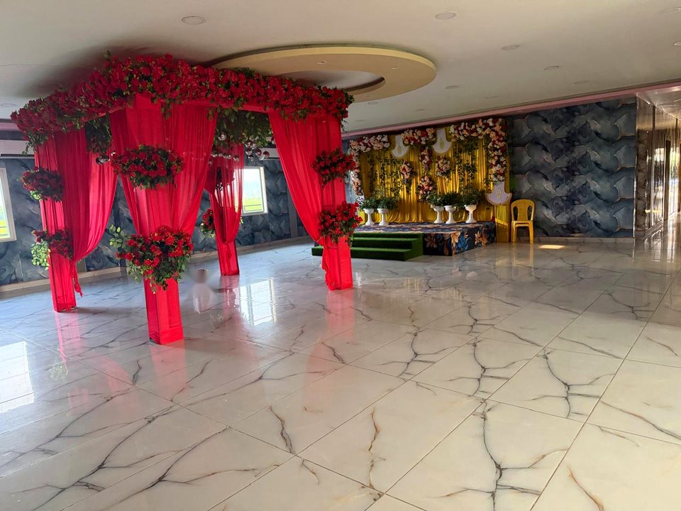 Indoor royal wedding mandap with red rose canopy and golden backdrop